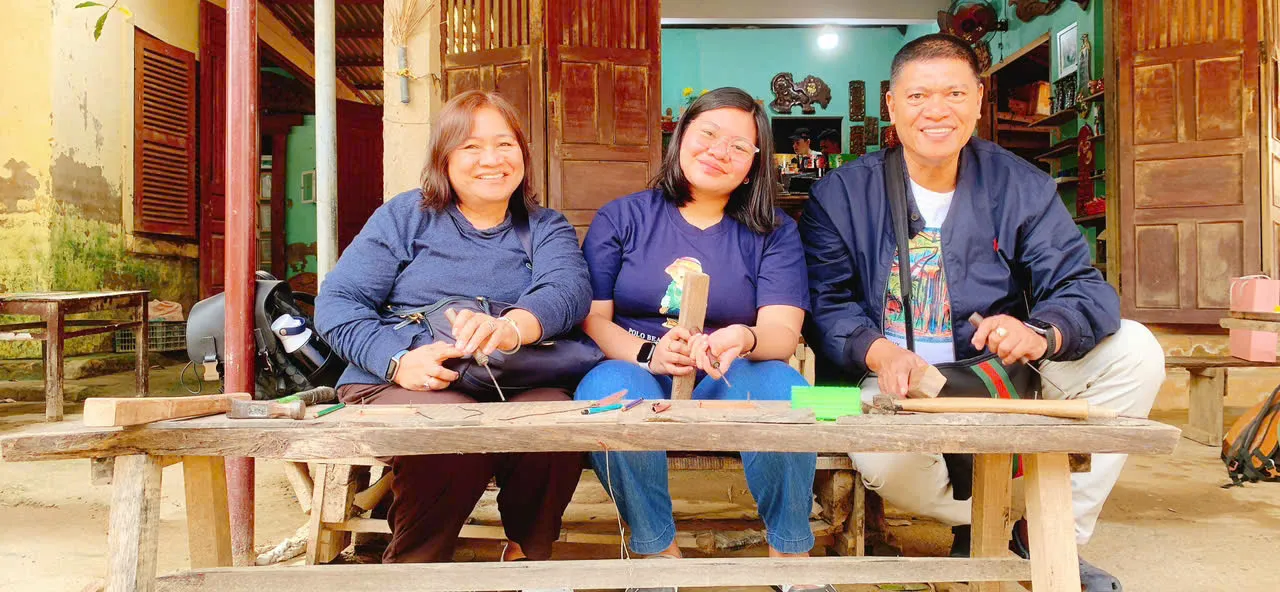 Guía Ao Dai recorriendo caminos rurales bordeados de palmeras