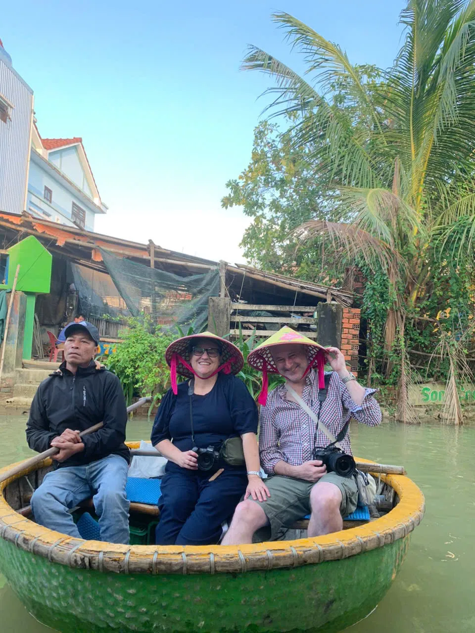 Des voyageurs flottent dans une barque panier en bambou dans la forêt de cocotiers de Hoi An