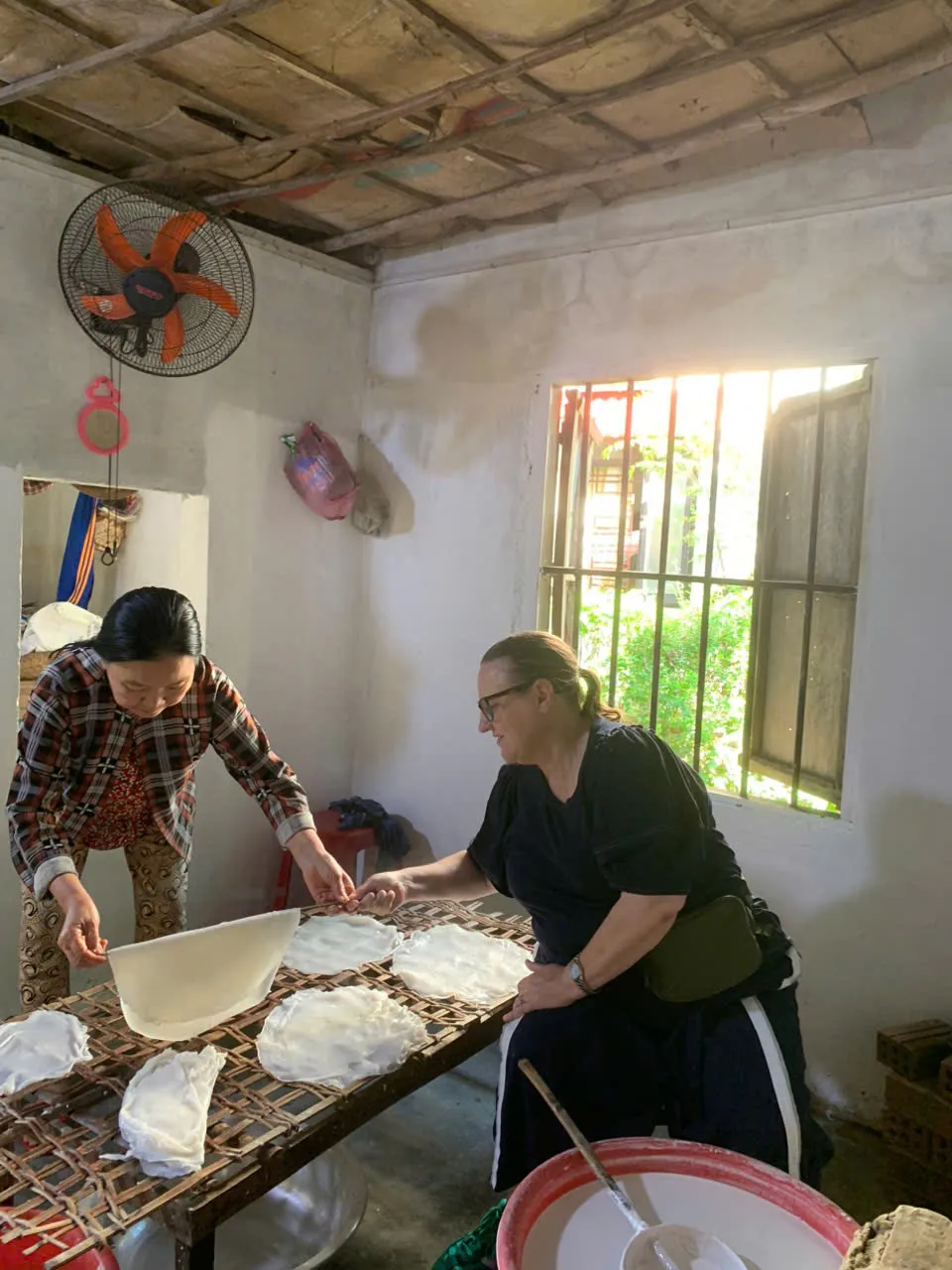 Des voyageurs préparent des feuilles de riz fraîches lors d'une halte dans un village de la campagne de Hoi An